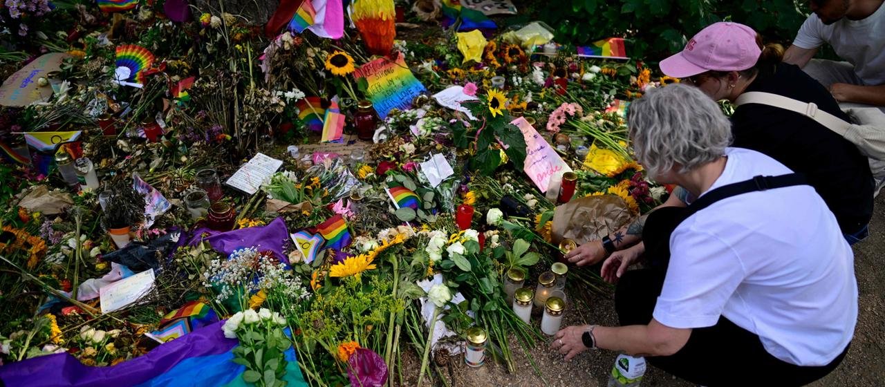 Menschen legen Blumen auf der Mahnwache für die Opfer des Anschlags auf dem CSD in Berlin nieder.