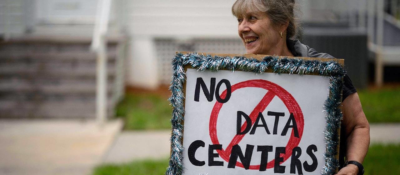 Eine Frau hält ein Schild mit der Aufschrift "No Data Centers"